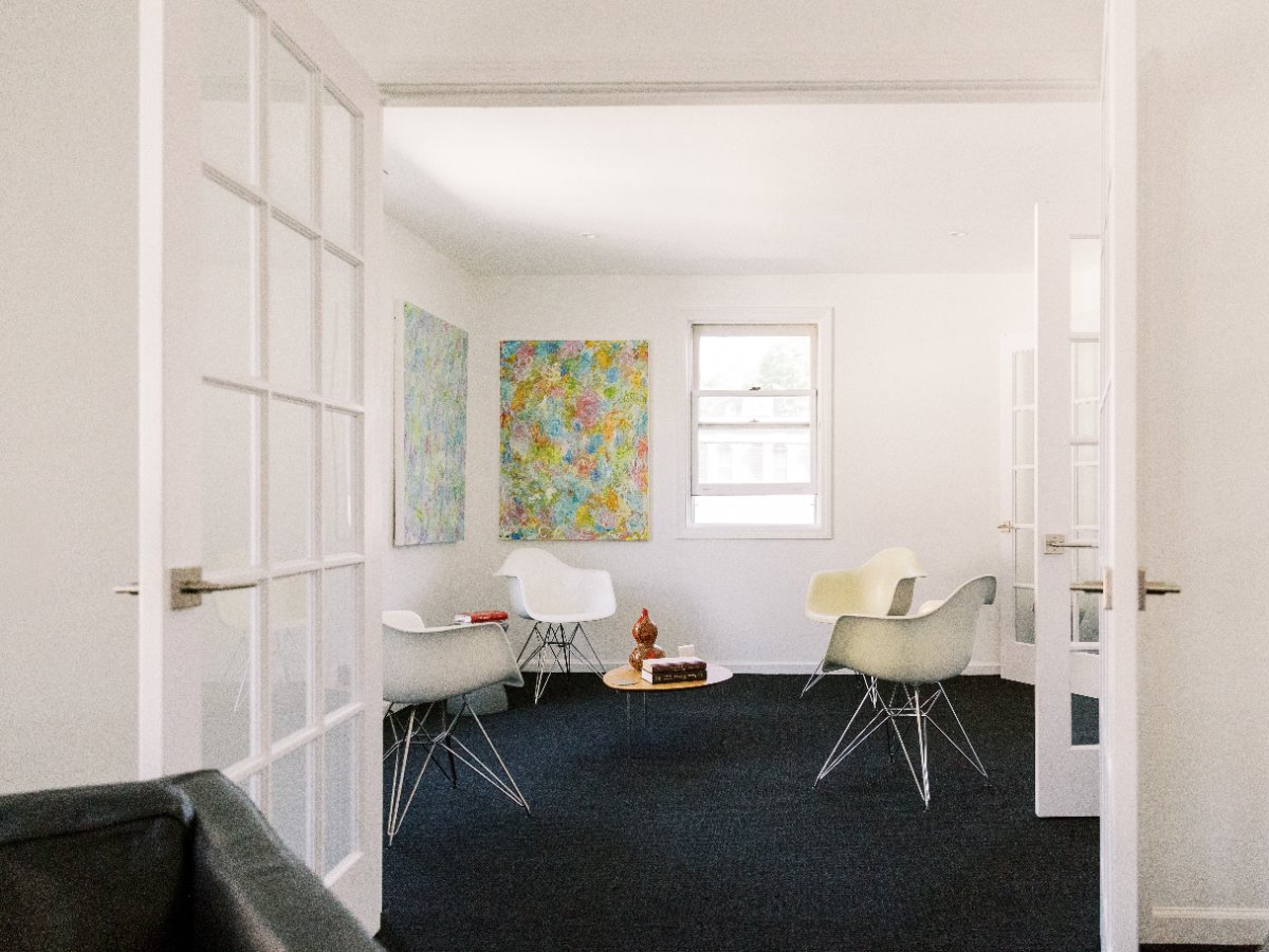 Consult room with white Eames chairs and colorful abstract art